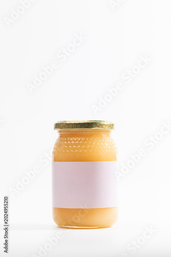 Golden jam in glass jar of natural rosemary honey with textured surface