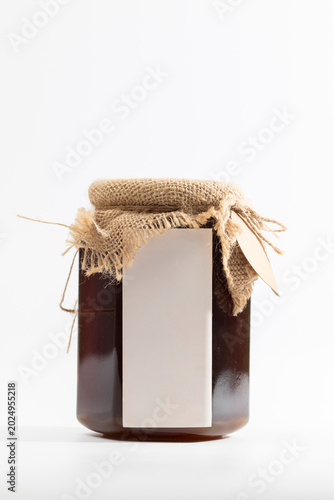 Warm honey jar sealed with rustic burlap