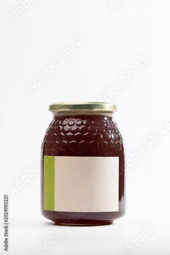 Glass jar holds rich, golden natural holm oak honey