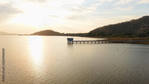 Fotografie Ban bang phra reservoir at golden hour with glimmering water and distant hills