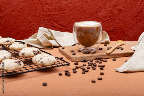Cookies and a cup of coffee with milk on a table.