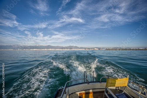 Bild auf Leinwand View from the stern of a fishing boat underway on the Tyrrhenian Sea near Viareggio, Italy, with a foamy wake and yellow equipment visible