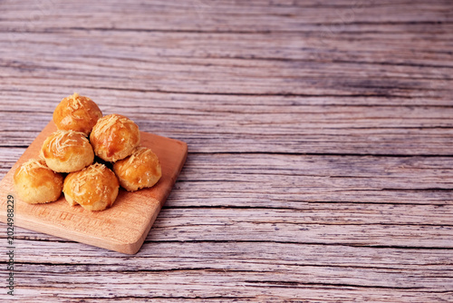 Tableau sur toile Kue Nastar or Golden pastries rest on a wooden board