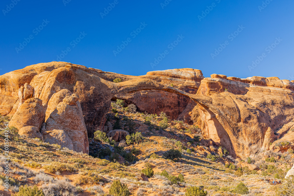 Naklejka premium The massive North Window arch spans rugged desert rock formations.