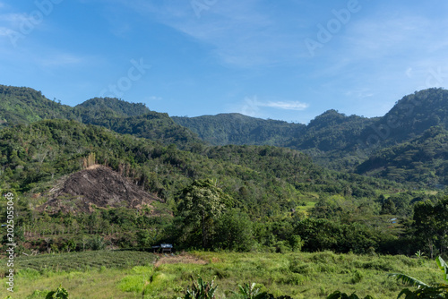 Scenic landscape of lush green mountain hills and rural agricultural field