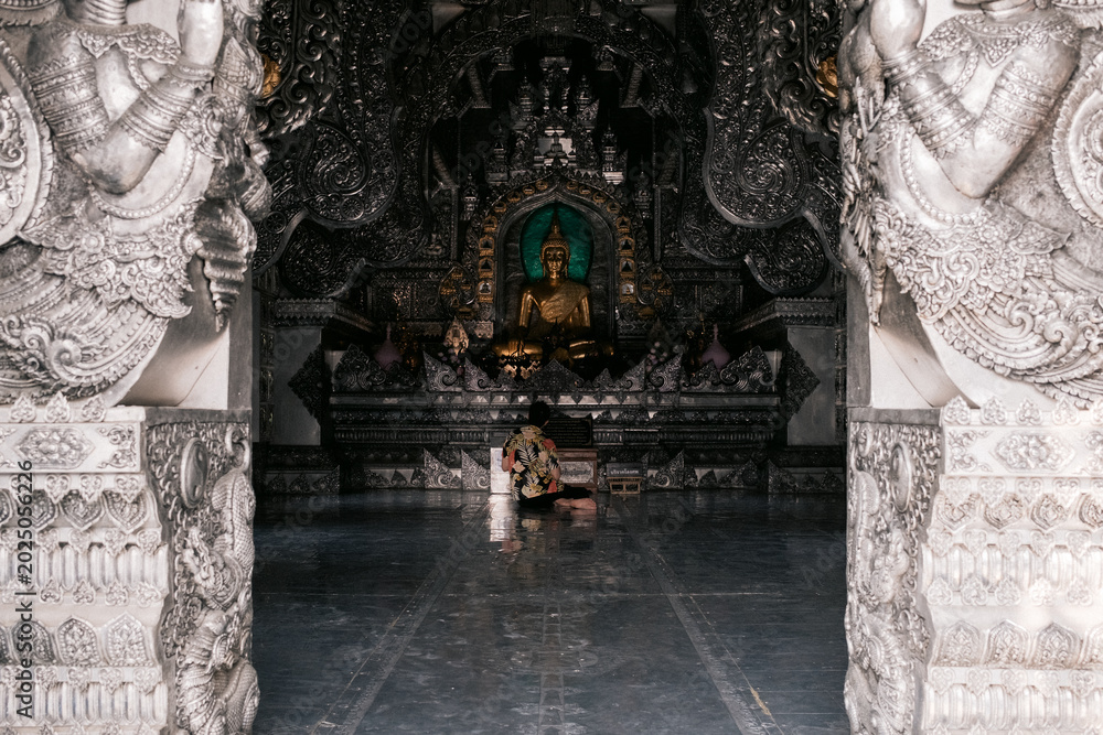 Obraz premium Ornate Buddhist temple interior seen through carved doorway in Chiang Mai, Thailand