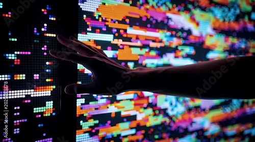 Hand Touching Colorful Pixelated Digital Wall of Light Patterns with ai generated
