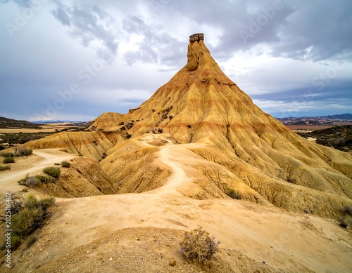 Dramatic Eroded Sandstone Hill Rising Under Stormy Sky in Arid Badlands