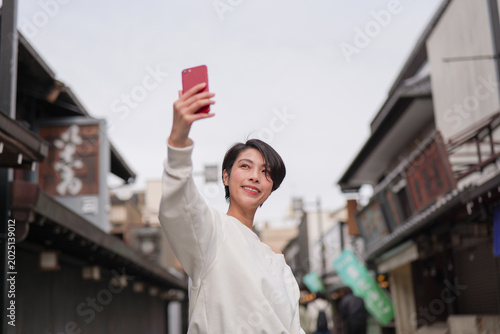 Foto 観光地でスマートフォンで写真を撮る女性