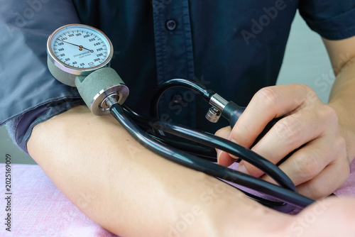 Fotografía hand of man using an aneroid sphygmomanometer to measure blood pressure on an arm, healthcare medical checkup, hypertension and cardiovascular monitoring concept