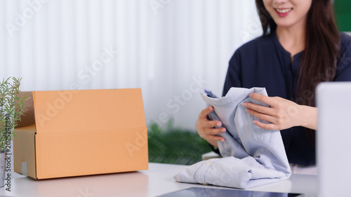 Foto Asian women live streaming online merchant selling clothing apparel product pres