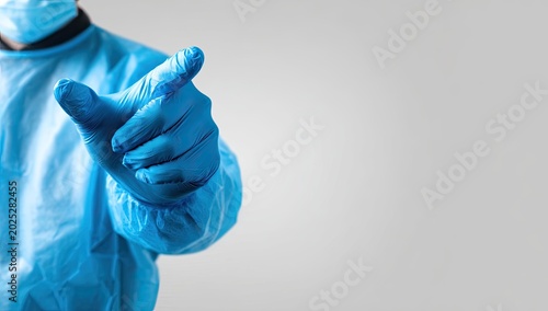 Person in protective suit, gloves, and mask gestures forward