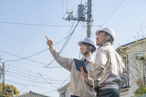 Photos 住宅地に立つ男性作業員のグループ