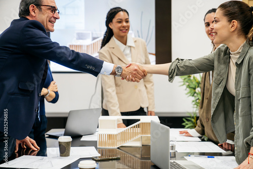 Photos Real estate professionals closing a deal with a handshake, discussing property i