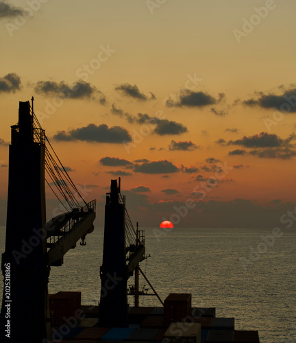 Bild auf Leinwand A merchant ship underway at sea in the evening