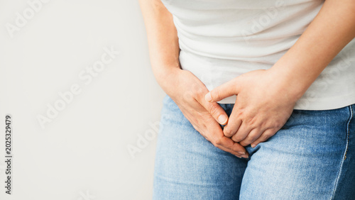 Young woman holding her groin