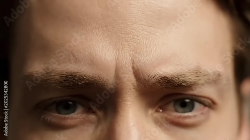 Close-up of a mans face, showing eyes, eyebrows, and forehead with expressions.