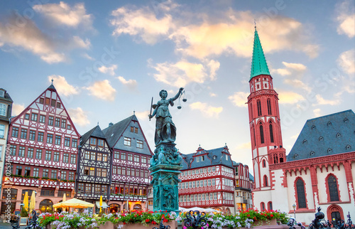 The Fountain of Justice at the center of the Römerberg, Frankfurt's historic medieval square, flanked by traditional half-timbered houses and the Old St. Nicholas Church.