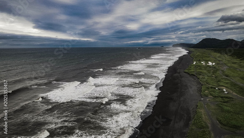 Obraz na plátne Dark volcanic sands and crashing waves along Khalaktyrsky Beach near Petropavlovsk-Kamchatsky, Russia, under dramatic skies