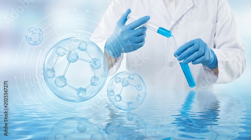 A scientist wearing white lab coat and blue protective gloves carefully adds a vibrant blue liquid from a syringe into a test tube surrounded by glowing digital molecular structure graphics