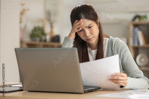 Foto Stressed Asian woman feeling worried about bill and debt