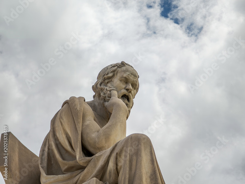 Thoughtful Socrates sculpture in a tight crop against a bright sky, capturing intellectual depth, silence, and timeless classical form.