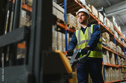 Konstfotografi Portrait of a handsome warehouse worker in overalls and a helmet