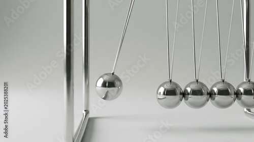 Close up of metal balls on newtons cradle physics toy in motion with pendulum momentum scientific equilibrium swinging movement education laboratory experiment