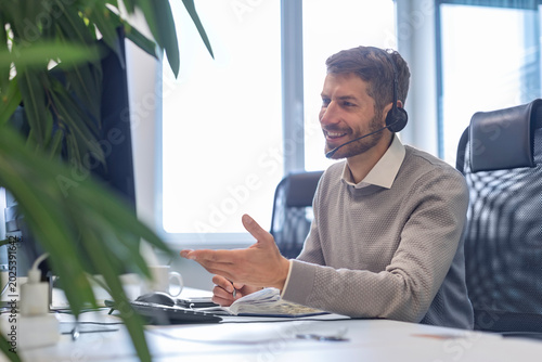 Smiling friendly handsome male call center operator.