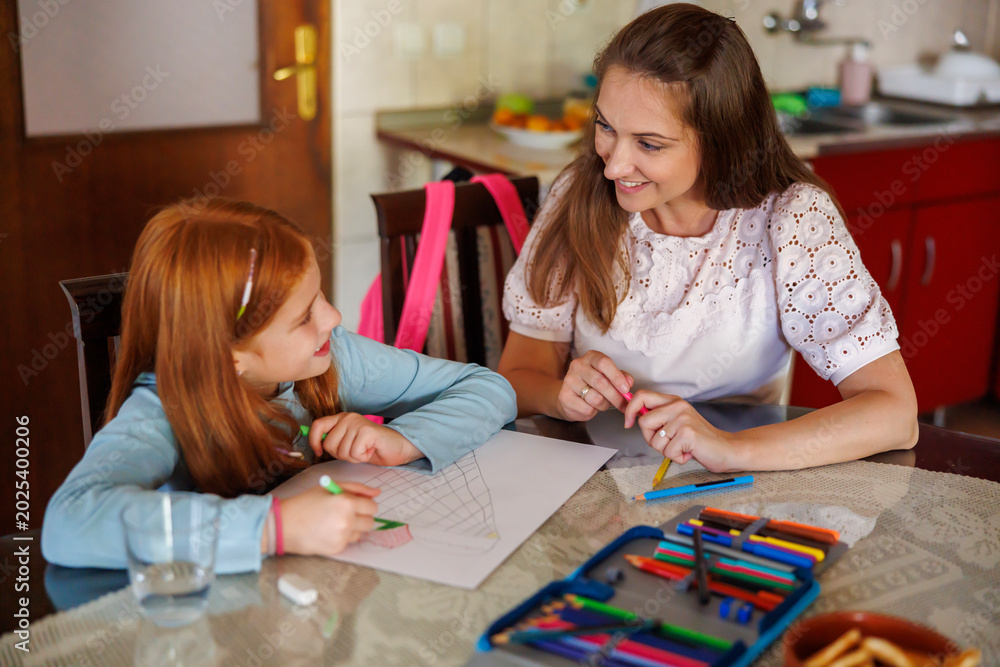 Fototapeta premium Mother helping daughter with art project for school