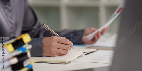 Canvas-taulu Professional writing in notebook and holding documents for business analysis