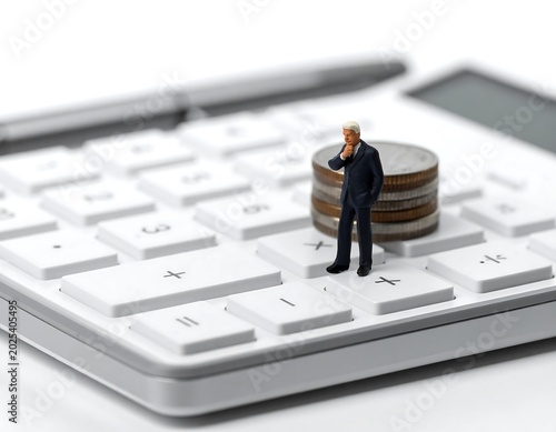Miniature businessman contemplating money on a calculator with a pen