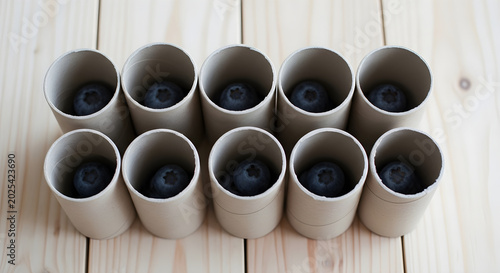 Rolls of paper tubes stacked on wooden planks with blue items inside