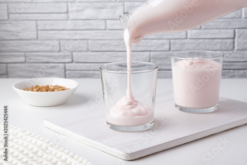 Photos Pouring homemade kefir, buttermilk or yogurt with probiotics