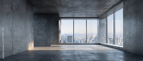 Modern architectural interior of an empty, concrete room with a large window overlooking a cityscape. Sun light floods the room