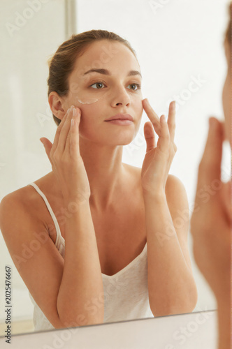 A Woman Looking at Her Face in the Mirror
