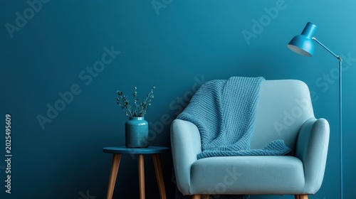 This image features a modern chair, blue wall, and a soft throw, capturing the essence of cozy and stylish interior design ideas for contemporary living spaces.