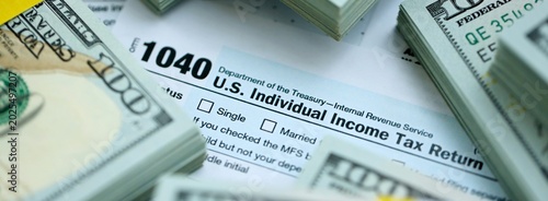 Cuadro en lienzo 1040 Individual Income tax return form and hundred dollars money bills packs on