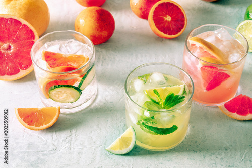 Refreshing summer cocktails with ice cubes on a light background