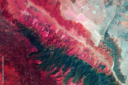 Vibrant aerial view of mountainous terrain with diverse vegetation patterns.