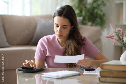 Woman doing accounting on a coffee table at home