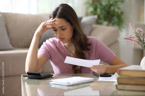 Worried woman complaining doing accounting at home