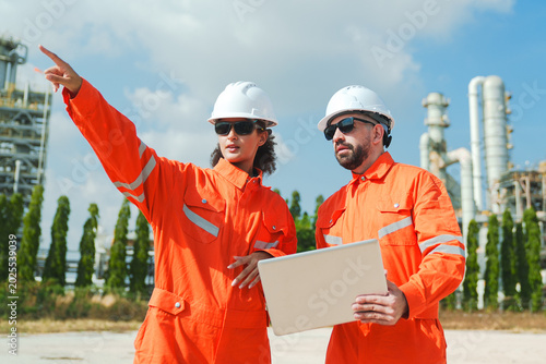 Photos Oil and gas refinery in petroleum industry with inspection engineer, industrial