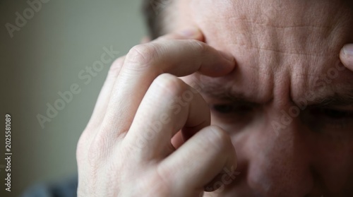 Close Up of Man Suffering from Headache and Stress, Fingers Pressing Forehead in Pain