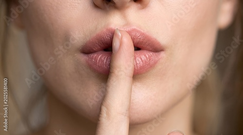 Woman with finger on her lips.