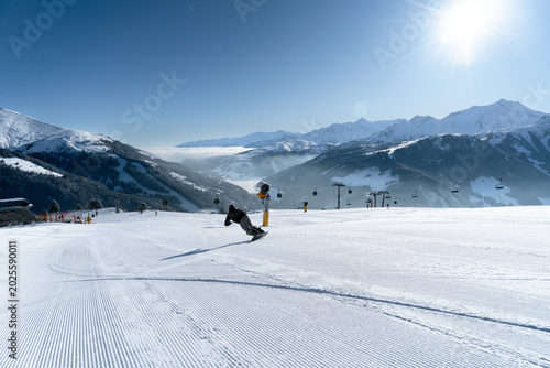 Foto Snowboarder carving auf perfekt präparierter Skipiste in den Alpen
