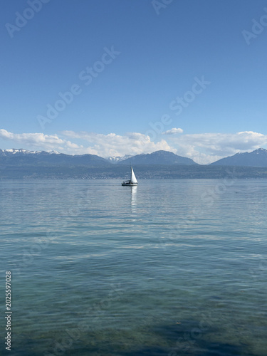 Single Boat on a Scenic Swiss Lake With Majestic Alpine Mountains Beneath a Clear Blue Sky