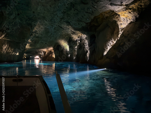 Saint-Léonard, Valais, Switzerland - May 02, 2026: Small Boat Floating on the Turquoise Still Waters of the Underground Lake Inside a Rocky Cave
