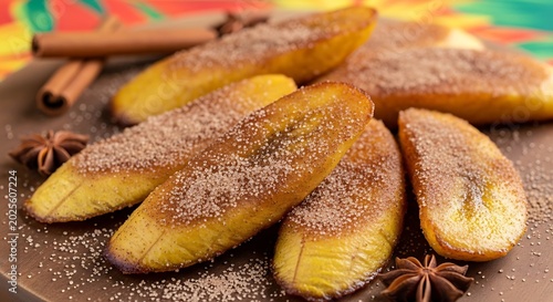 perfectly fried plantain slices dusted with cinnamon and sugar, served on a wooden board with star anise and cinnamon sticks.