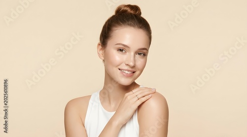 Young Caucasian woman beauty portrait with radiant skin and beige background